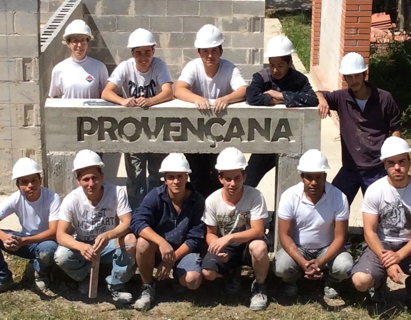 Alumnat de Construcció amb casc davant el rètol de l'institut